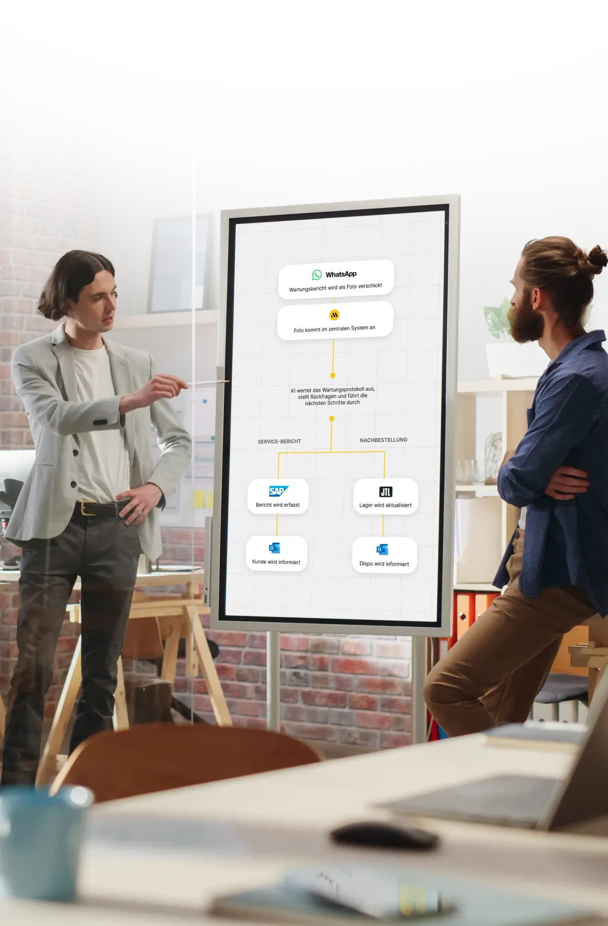 Zwei Kollegen besprechen einen Prozessablauf am digitalen Whiteboard