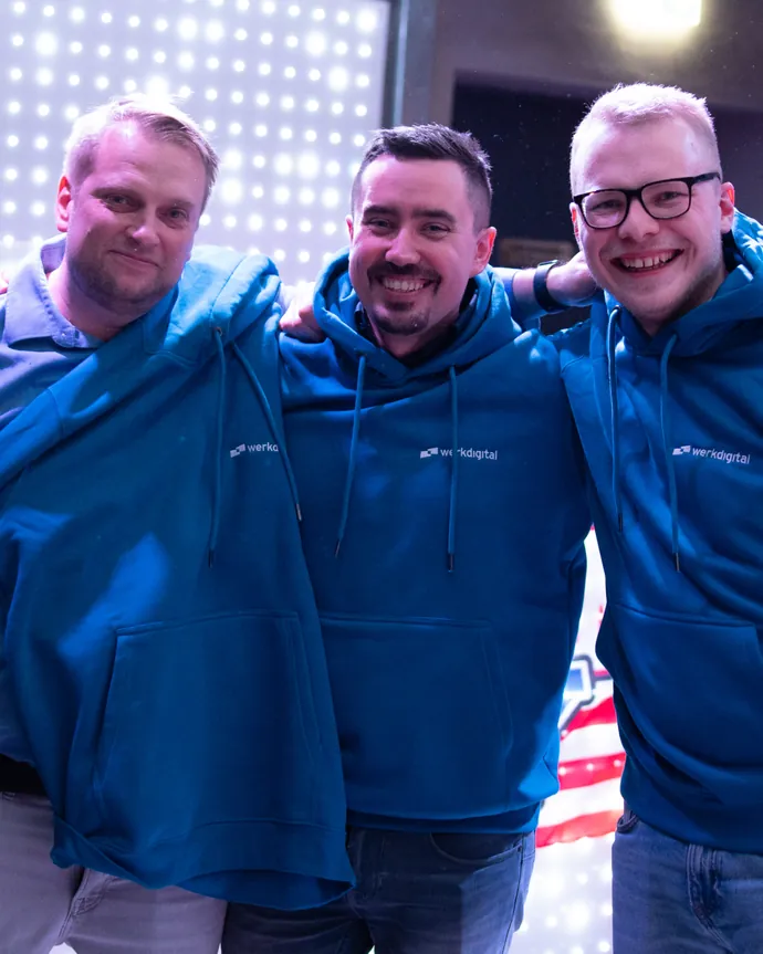 Drei Kollegen in blauen Werkdigital-Hoodies