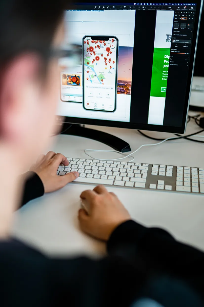 Entwickler am Arbeitsplatz mit App-Entwurf auf dem Bildschirm